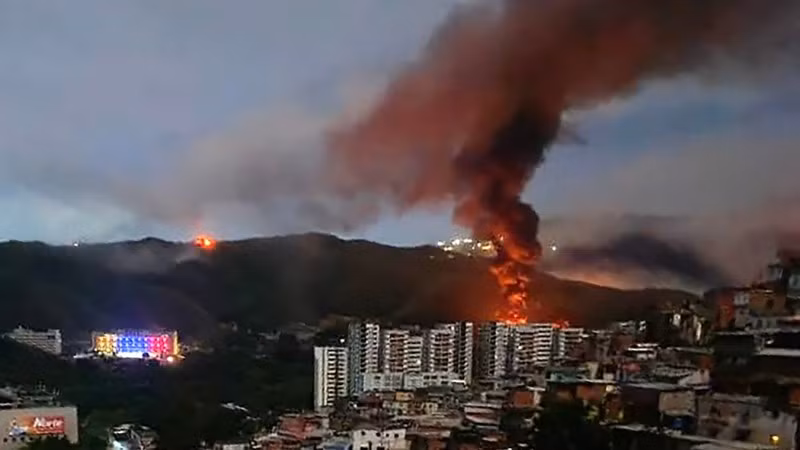 Khói lửa bốc lên tại khu phức hợp quân sự Fuerte Tiuna lớn nhất Venezuela, sau một loạt tiếng nổ ở Thủ đô Caracas, ngày 3/1/2026. (Ảnh: France24/TTXVN)