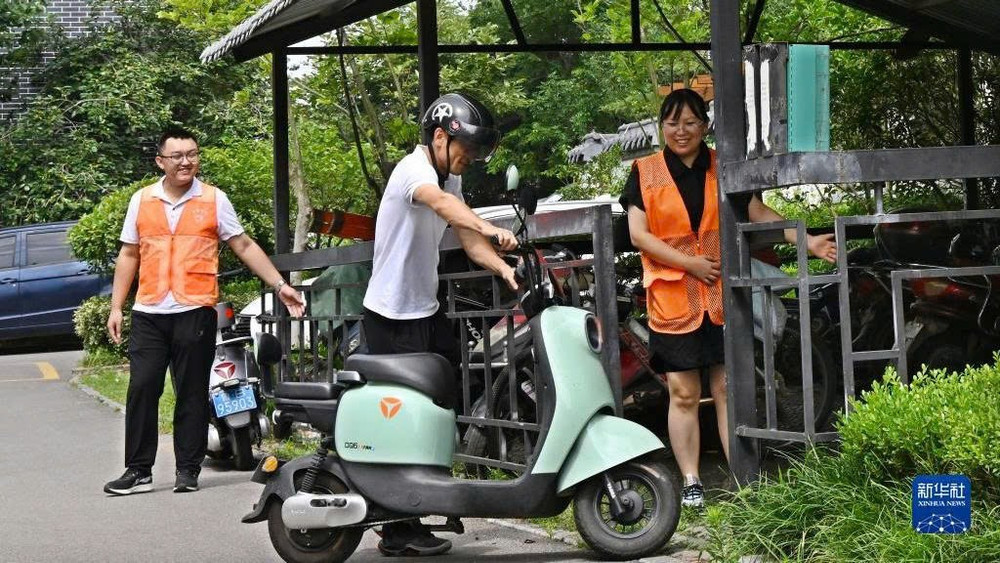 Nhân viên hướng dẫn người dân đưa xe điện vào điểm sạc pin tập trung ở thành phố Giao Châu, Thanh Đảo, tỉnh Sơn Đông, Trung Quốc. (Ảnh: Tân Hoa xã)