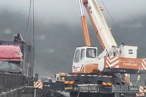 Lực lượng chức năng giải cứu xe bị trơn trượt dẫn tới va chạm do mưa bão số 10 gây ra.