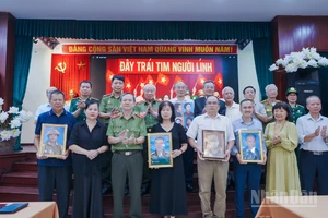 Đại diện các gia đình đón nhận di ảnh anh hùng liệt sĩ tại sự kiện. 