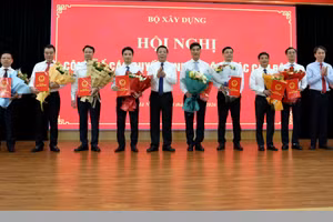 Bộ trưởng Trần Hồng Minh trao Quyết định và tặng hoa chúc mừng các cán bộ mới được bổ nhiệm. (Ảnh: Cổng thông tin bộ Xây dựng)