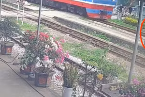 Cụ bà được công nhân đường sắt Dương Văn Kiên cứu chỉ 2 giây trước khi đoàn tàu chạy qua. (Ảnh cắt từ camera ghi lại)