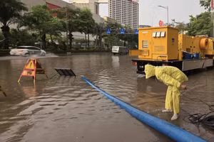 Nhân viên Công ty Thoát nước Hà Nội ứng trực tại điểm "dềnh nước" trên đường Võ Chí Công. (Nguồn: TTXVN)
