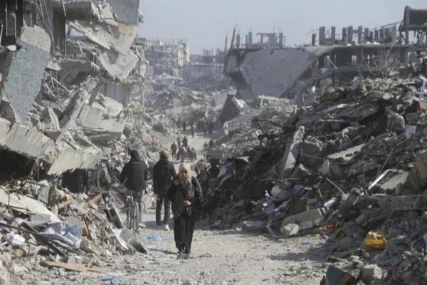 Người dân Palestine trên một con phố có những tòa nhà bị phá hủy tại trại tị nạn Jabalia ở phía bắc Dải Gaza, vào ngày 29/1/2025. (Ảnh: Tân Hoa xã)