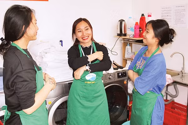 Lương Thị Kiều Thúy (người đứng giữa) trao đổi công việc cùng các đồng nghiệp. 