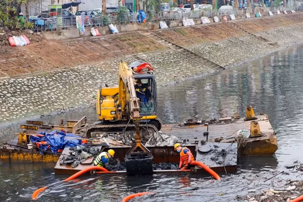 Công nhân Công ty Thoát nước Hà Nội tiến hành nạo vét bùn trên sông Tô Lịch. (Ảnh: DUY LINH)