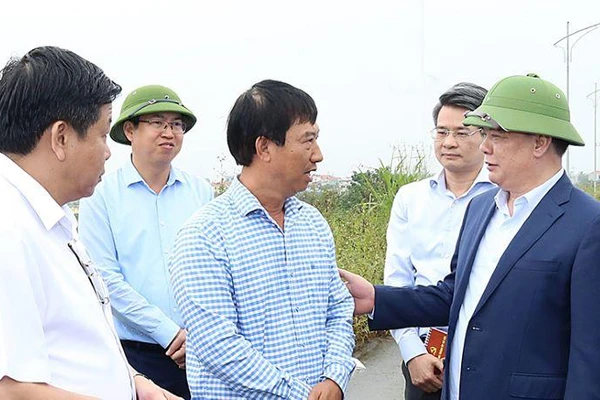 Đồng chí Đinh Tiến Dũng trò chuyện với người dân có đất nằm trong dự án Vành đai 4-Vùng Thủ đô trên địa bàn huyện Hoài Đức.