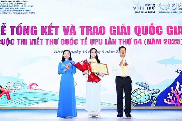 Minh Khuê (đứng giữa) nhận bằng khen và hoa trong lễ tổng kết và trao giải.