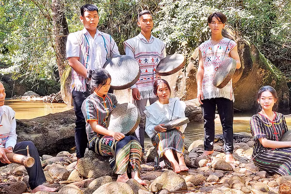 Nghệ nhân già truyền dạy các em học sinh sử dụng nhạc cụ truyền thống.