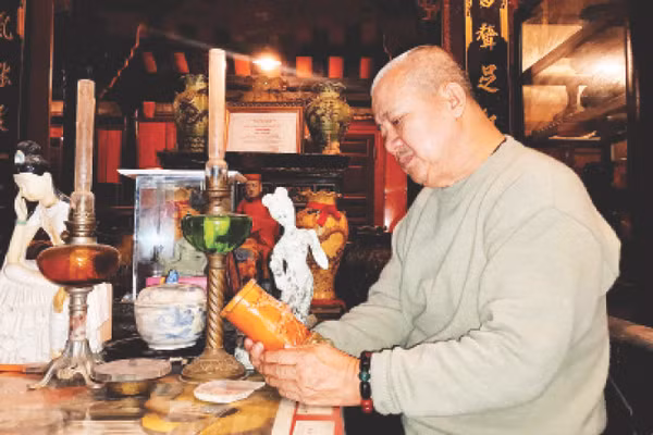 Ông Lâm Dũ Xênh trầm tư cùng gốm cổ.