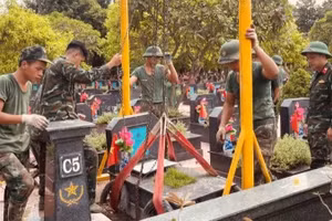 Các chiến sĩ cẩn trọng di chuyển phần mộ liệt sĩ. (Ảnh: ĐẮC SƠN)