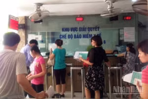 Người dân làm thủ tục đăng ký khám bệnh, chữa bệnh bảo hiểm y tế tại Bệnh viện. (Ảnh: ĐỖ THOA)