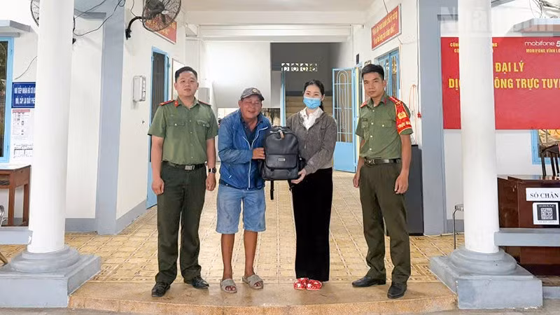 Công an Long Hồ hỗ trợ người dân nhận lại tài sản. (Ảnh: CA cung cấp)