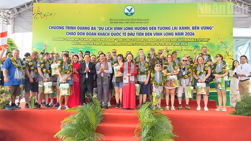 Lãnh đạo tỉnh Vĩnh Long trao quà cho khách quốc tế đầu tiên đến Vĩnh Long. 