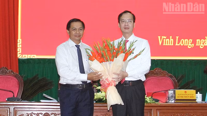 Bí thư Tỉnh ủy Vĩnh Long Trần Văn Lâu tặng hoa chúc mừng tân Chủ tịch Ủy ban nhân dân tỉnh Vĩnh Long Trần Trí Quang. 