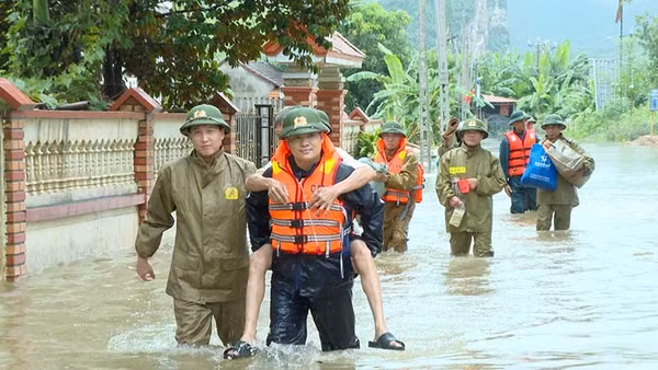 Công an xã Cẩm Tú giúp dân di chuyển người, đồ dùng khỏi khu vực bị ngập nước. (Ảnh: Công an Thanh Hóa)