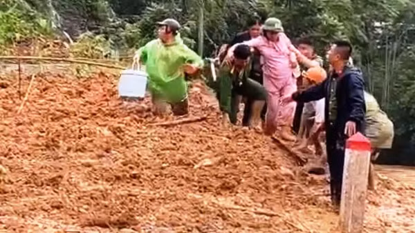 Công an hỗ trợ sản phụ vượt qua điểm tắc đường do sạt lở. (Ảnh: Công an Thanh Hóa)