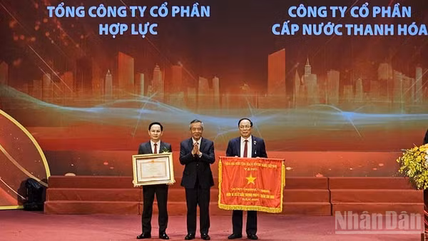 Hai doanh nghiệp tiêu biểu của tỉnh Thanh Hóa vinh dự đón Cờ thi đua và Bằng khen của Thủ tướng Chính phủ. (Ảnh: MAI LUẬN)