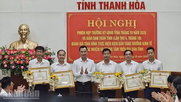 Chủ tịch tỉnh Thanh Hóa trao tặng bằng khen cho tập thể, cá nhân ở xã Hoằng Thanh có thành tích xuất sắc trong giải phóng mặt bằng thực hiện dự án đầu tư công. (Ảnh: Mai Luận)