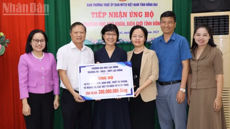 Đại diện Ủy ban Mặt trận Tổ quốc Việt Nam tỉnh Đồng Nai cùng Sở Giáo dục và đào tạo tiếp nhận bảng tượng trưng số máy vi tính, dụng cụ học tập.