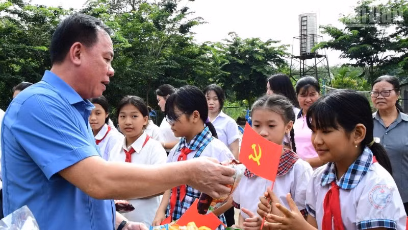 Đồng chí Võ Tấn Đức, Phó Bí thư Tỉnh ủy, Bí thư Đảng ủy, Chủ tịch Ủy ban nhân tỉnh Đồng Nai cùng với trẻ em và người dân khu vực biên giới xã Thanh Hòa.