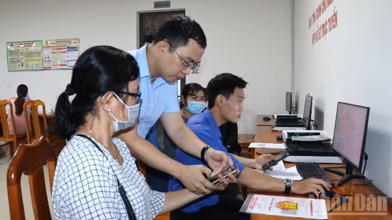 Lãnh đạo xã Long Thành hướng dẫn người dân nộp hồ sơ trực tuyến tại Trung tâm Phục vụ hành chính công.