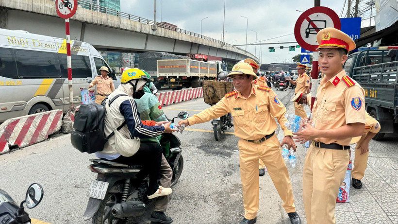 Cảnh sát giao thông Công an tỉnh Đồng Nai phát nước suối cho người dân trên Quốc lộ 1A.