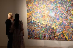 Họa sĩ Hoàng Anh Trung chia sẻ với phóng viên về quá trình sáng tạo. (Ảnh: Mơ Art Space)