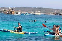 Du khách trải nghiệm lặn biển ngắm san hô, chèo sup tại khu vực Bãi Cạn, Phú Quý. (Ảnh: TTXVN)