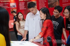 Du khách trải nghiệm sách tương tác tại Triển lãm "95 năm Cờ Đảng soi đường".