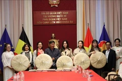 Ông Đỗ Phước Trung, Phó Giám đốc Sở Văn hóa và Thể thao Thành phố Hồ Chí Minh, trao tặng sách cho ông Huỳnh Công Mỹ, Chủ tịch Tổng hội người Việt Nam tại Vương quốc Bỉ. (Ảnh: TTXVN)