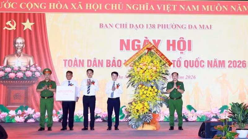 Thượng tướng Nguyễn Văn Long (ngoài cùng, bên phải) tặng hoa chúc mừng cán bộ, nhân dân phường Đa Mai tại ngày hội. (Ảnh: LINH THẠCH)