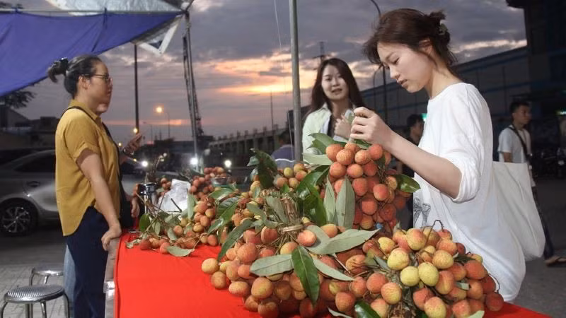 Công nhân khu công nghiệp Nội Hoàng, Bắc Giang trải nghiệm gian hàng vải thiều sau giờ tan ca.