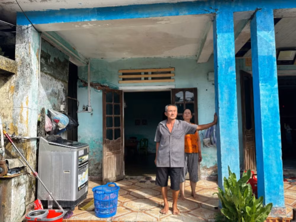 Vợ chồng ông Nguyễn Lê thất thần trước ngôi nhà có thể sập bất cứ lúc nào. (Ảnh: ANH ĐÀO)