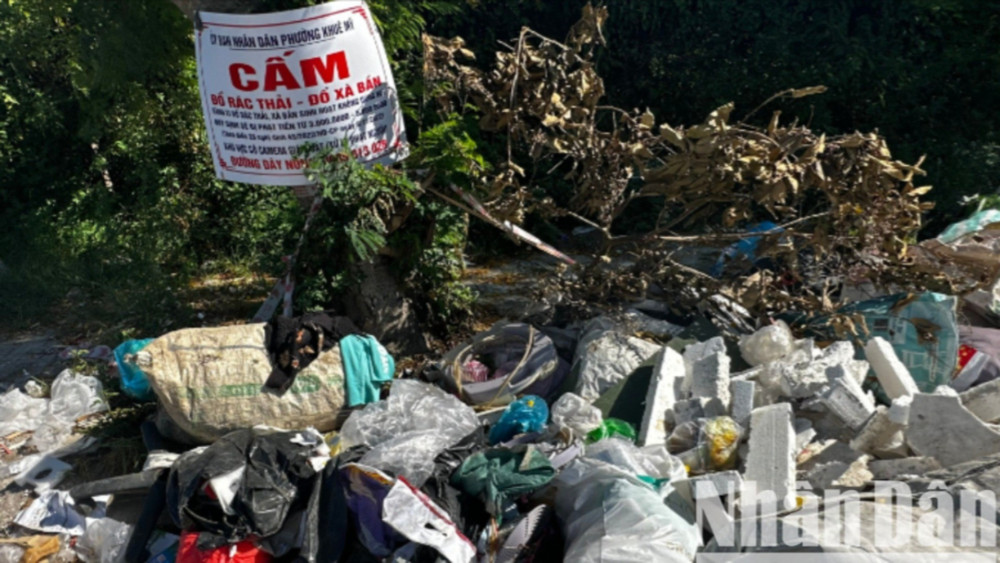 Vô tư đổ rác ngay biển cấm đổ rác. (Ảnh: BẢO KHÁNH)