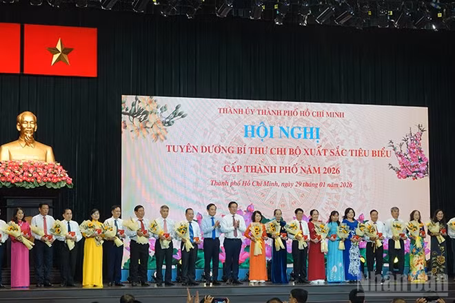 Lãnh đạo Thành phố Hồ Chí Minh trao tặng biểu trưng và hoa chúc mừng các đồng chí Bí thư chi bộ được tuyên dương. (Ảnh Linh Bảo)