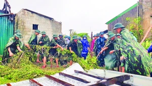 Cán bộ, chiến sĩ Trung đoàn 841 giúp người dân xã Cẩm Trung khắc phục thiệt hại do tố, lốc gây ra.