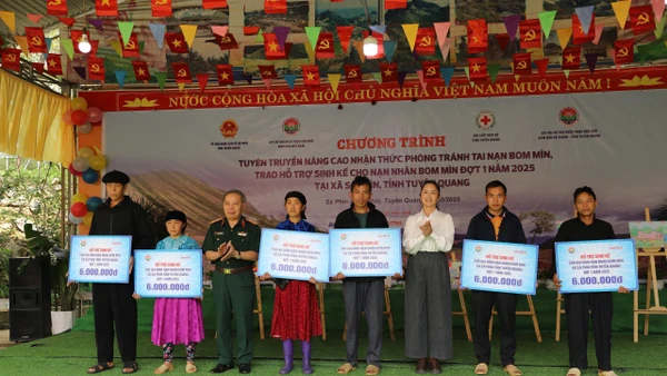 Trung tướng Phạm Ngọc Khóa, Phó Chủ tịch thường trực Hội Hỗ trợ khắc phục hậu quả Bom mìn Việt Nam và đồng chí Lý Thị Kiên, Phó Bí thư thường trực xã Sà Phìn trao hỗ trợ. sinh kế cho gia đình các nạn nhân bom mìn.