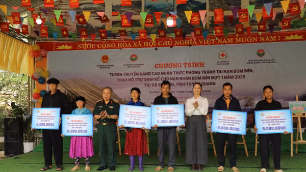 Trung tướng Phạm Ngọc Khóa, Phó Chủ tịch thường trực Hội Hỗ trợ khắc phục hậu quả Bom mìn Việt Nam và đồng chí Lý Thị Kiên, Phó Bí thư thường trực xã Sà Phìn trao hỗ trợ. sinh kế cho gia đình các nạn nhân bom mìn.