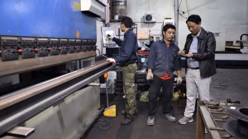 Anh Lê Lương Nguyên (ngoài cùng bên phải) trao đổi với lao động trong xưởng.