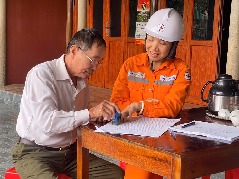 Cán bộ Điện lực Hương Sơn hướng dẫn khách hàng ký cam kết tiết kiệm điện.
