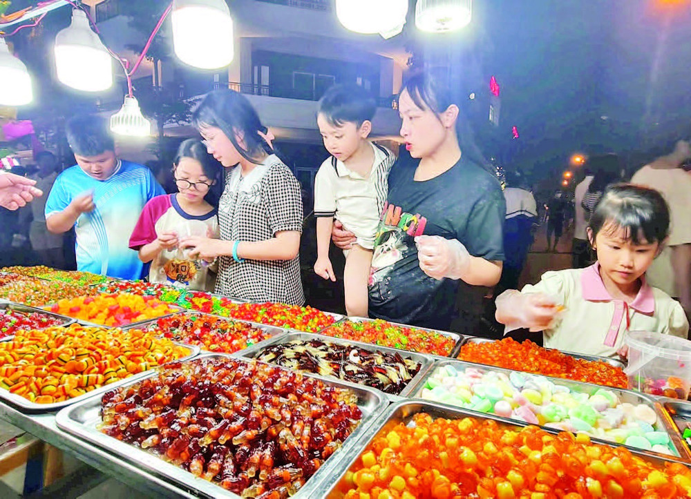 Du khách mua hàng tại một gian ẩm thực ở phố đi bộ Đinh Tiên Hoàng, phường Trần Lãm, tỉnh Hưng Yên.