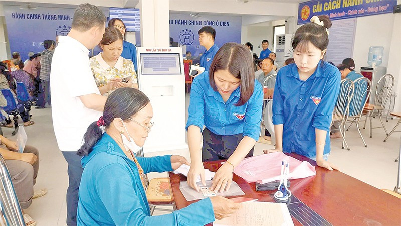 Đoàn viên, thanh niên xã Ô Diên hướng dẫn người dân rà soát lại hồ sơ trước khi nộp thủ tục hành chính.