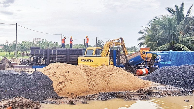 Lực lượng thi công Dự án Đường tỉnh 927 tranh thủ trở lại công trường sau cơn mưa.