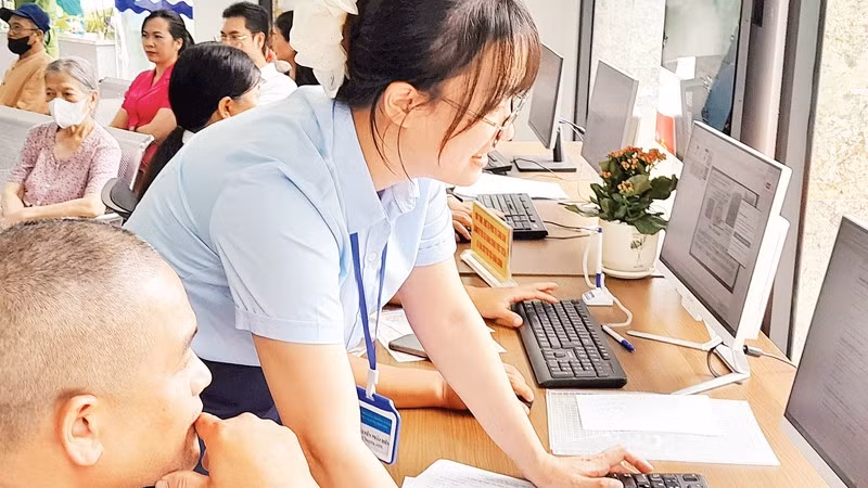 Cán bộ Điểm phục vụ Hành chính công phường Tây Hồ hướng dẫn người dân làm thủ tục hành chính trên môi trường mạng.