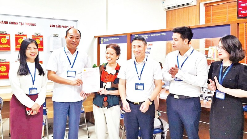 Lãnh đạo phường Định Công trao sổ đỏ cho người dân.