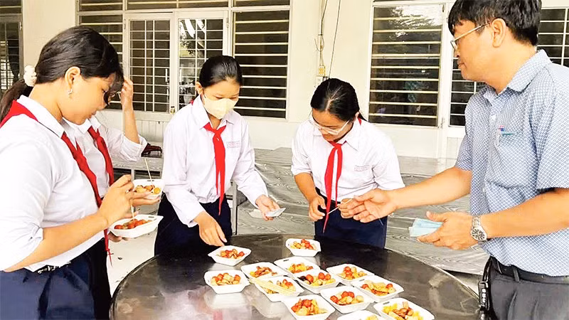 Bữa ăn hỗ trợ học sinh có hoàn cảnh khó khăn tại Trường trung học cơ sở Trần Hưng Đạo (phường Bình Đức, tỉnh An Giang).