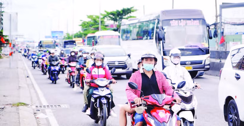 Xe máy lưu thông trên Quốc lộ 1, đoạn qua cầu Bình Điền. (Ảnh THẾ ANH)