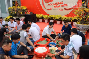 Đông đảo cán bộ, nhân viên người Việt và người Campuchia của Công ty Metfone tham gia hoạt động cùng nhau gói bánh chưng ngày Tết. (Ảnh: HUY VŨ)