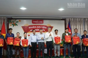 Đại sứ Việt Nam tại Campuchia Nguyễn Minh Vũ cùng đại diện Ban tổ chức trao tặng quà Tết cho bà con gốc Việt có hoàn cảnh khó khăn. (Ảnh: ĐINH TRƯỜNG)